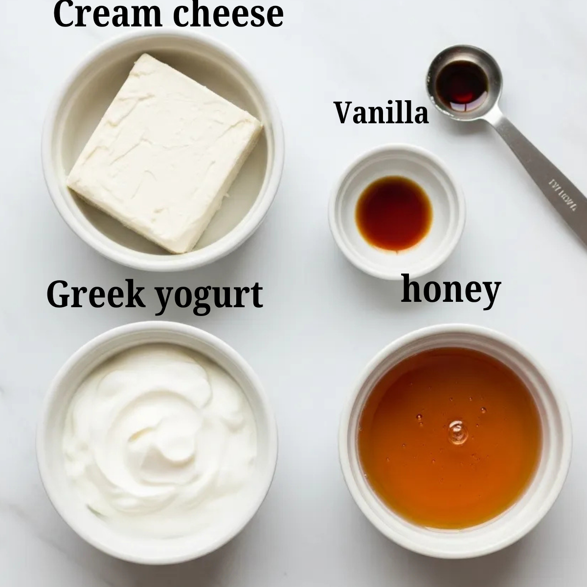 Flat lay of ingredients for a light cream cheese frosting, including cream cheese, Greek yogurt, maple syrup, and vanilla extract in small white bowls on a marble background.