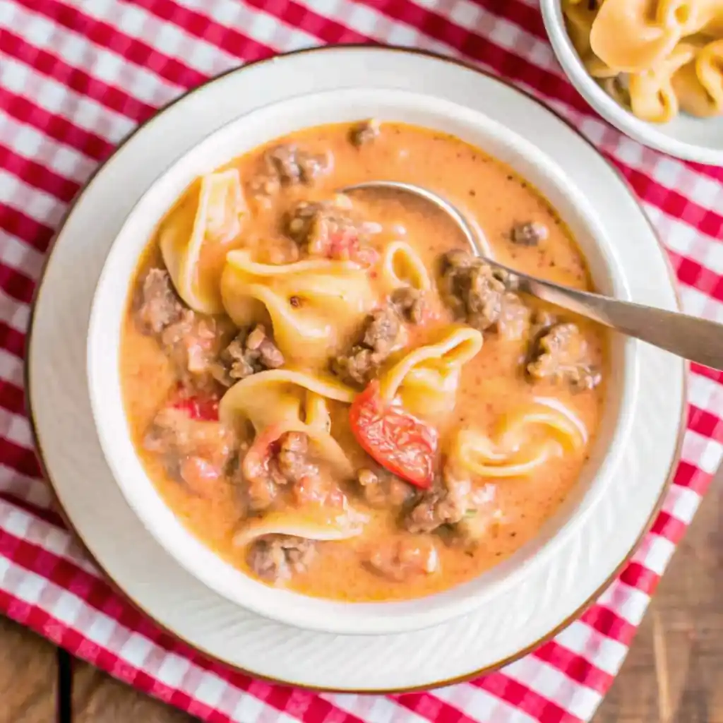 Creamy crockpot tomato tortellini soup with sausage served in a bowl