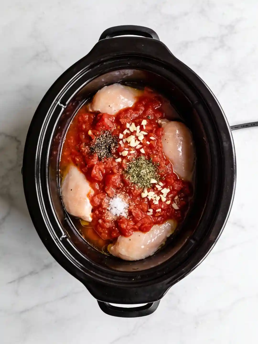Chicken broth being poured into a slow cooker for chicken parmesan soup