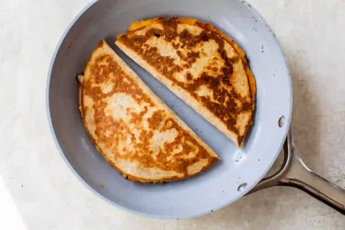 chicken-quesadilla-step-5-cook-to-crisp_compressed Golden chicken quesadilla cooking in a skillet until crisp on the outside