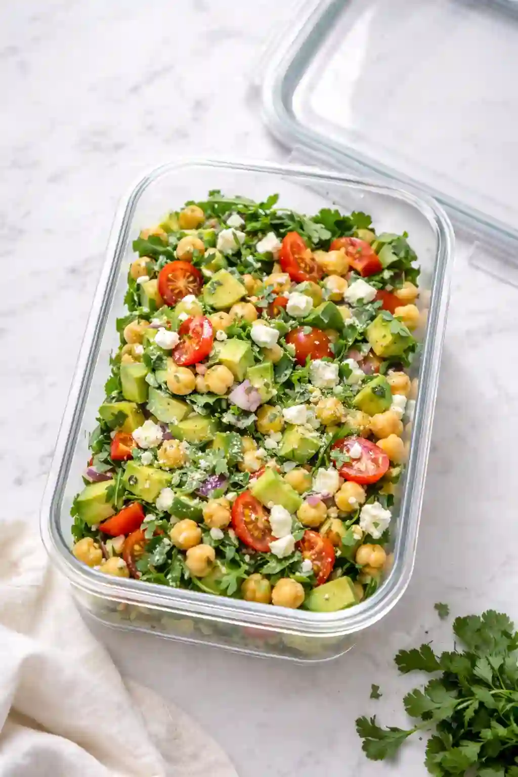 Chickpea feta avocado salad stored in an airtight glass container.