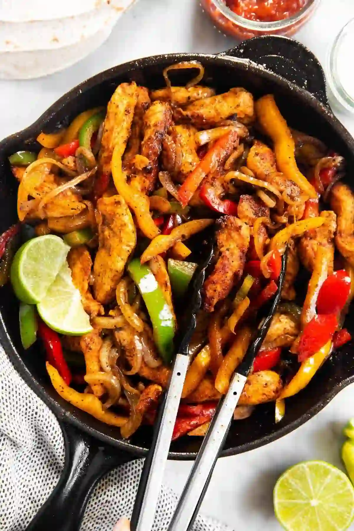 easy-chicken-fajitas-step-4-combine-serve_compressed Chicken fajitas with peppers and onions combined in a cast-iron skillet