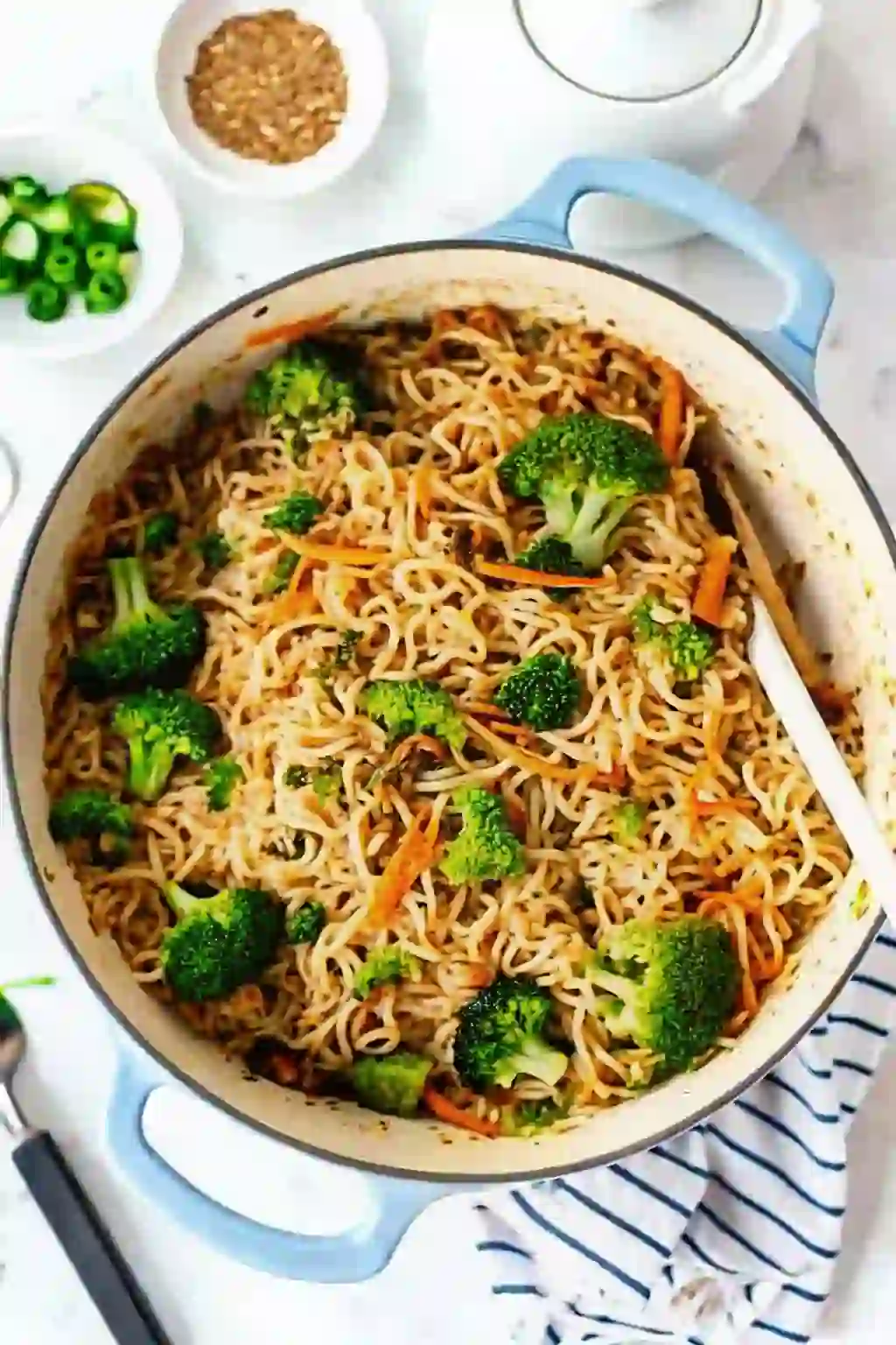 Ground beef noodle stir fry with ramen, broccoli, and carrots in a skillet