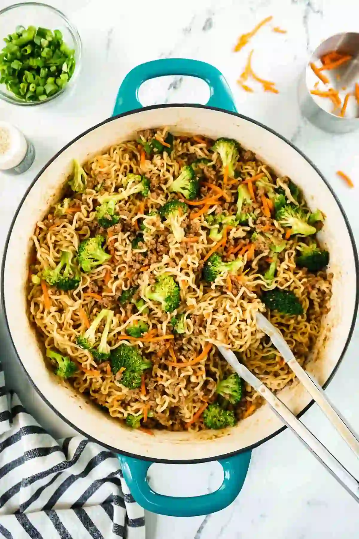 Ground beef noodle stir fry with broccoli and carrots tossed in a skillet