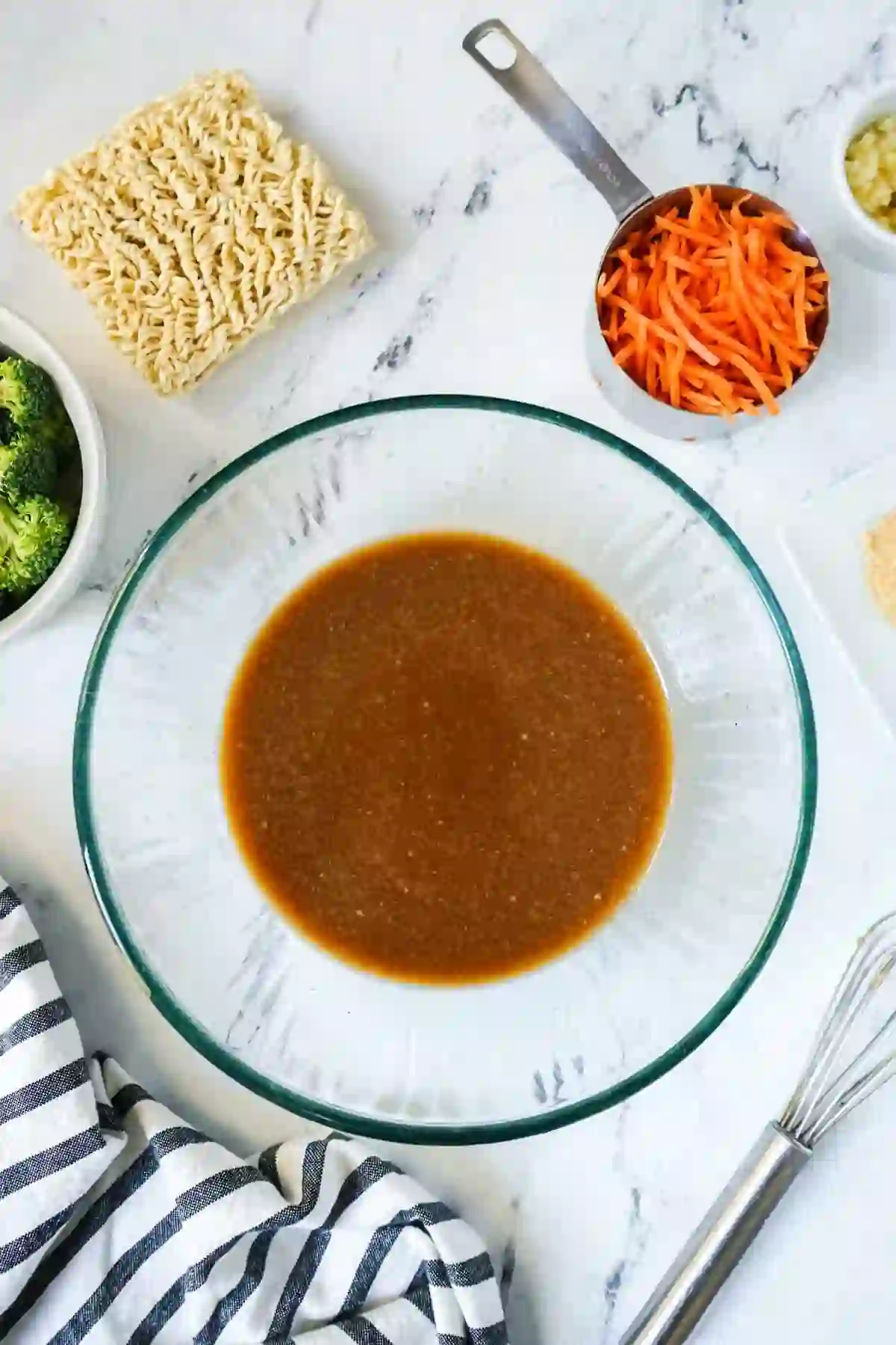 Homemade stir fry sauce whisked in a glass bowl on a white countertop