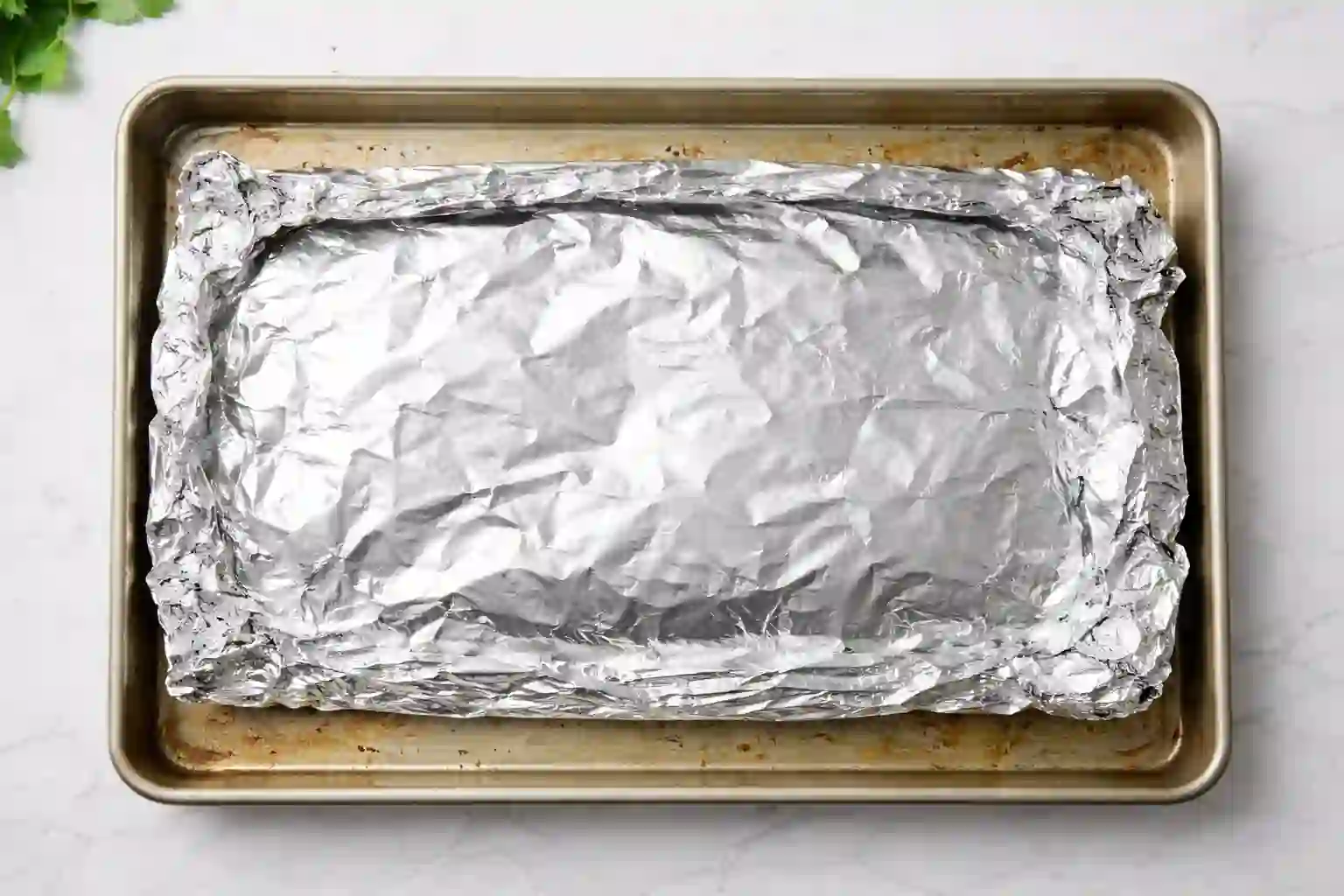 baked-salmon-step-3-baking._compressed (1) Foil-wrapped salmon baking on a rimmed sheet pan