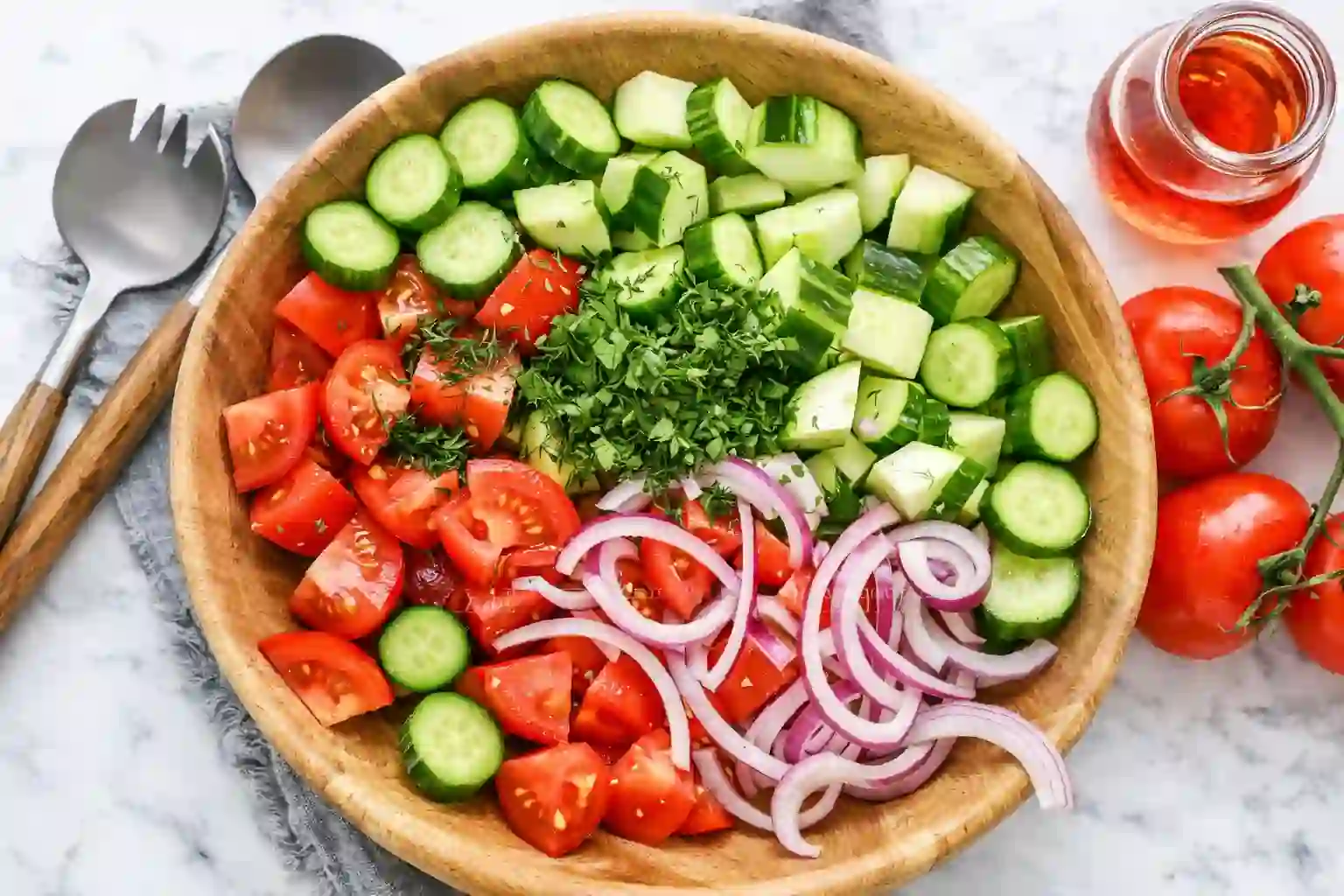 cucumber-tomato-salad-step-1._compressed (1) Mixing cucumber, tomato, and red onion with olive oil and vinegar in a bowl