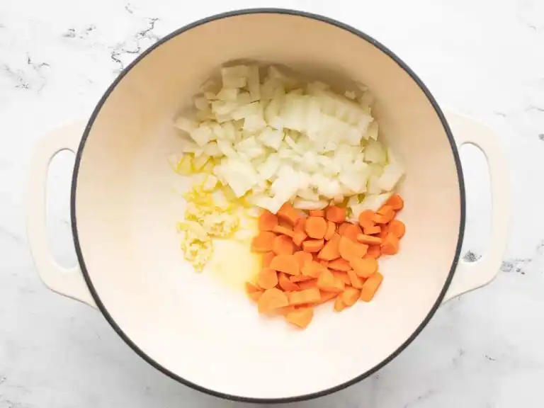 saute-garlic-onion-carrots._compressed Garlic, onion, and carrots sautéing in olive oil in a large pot.