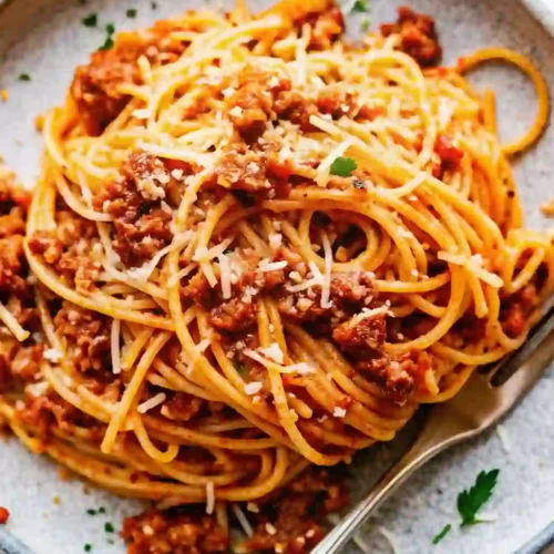 Slow-simmered spaghetti bolognese with rich meat sauce and grated Parmesan cheese.