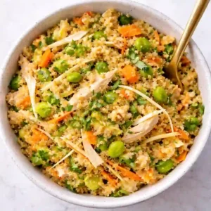 Overhead Thai peanut quinoa salad with chicken in a white bowl