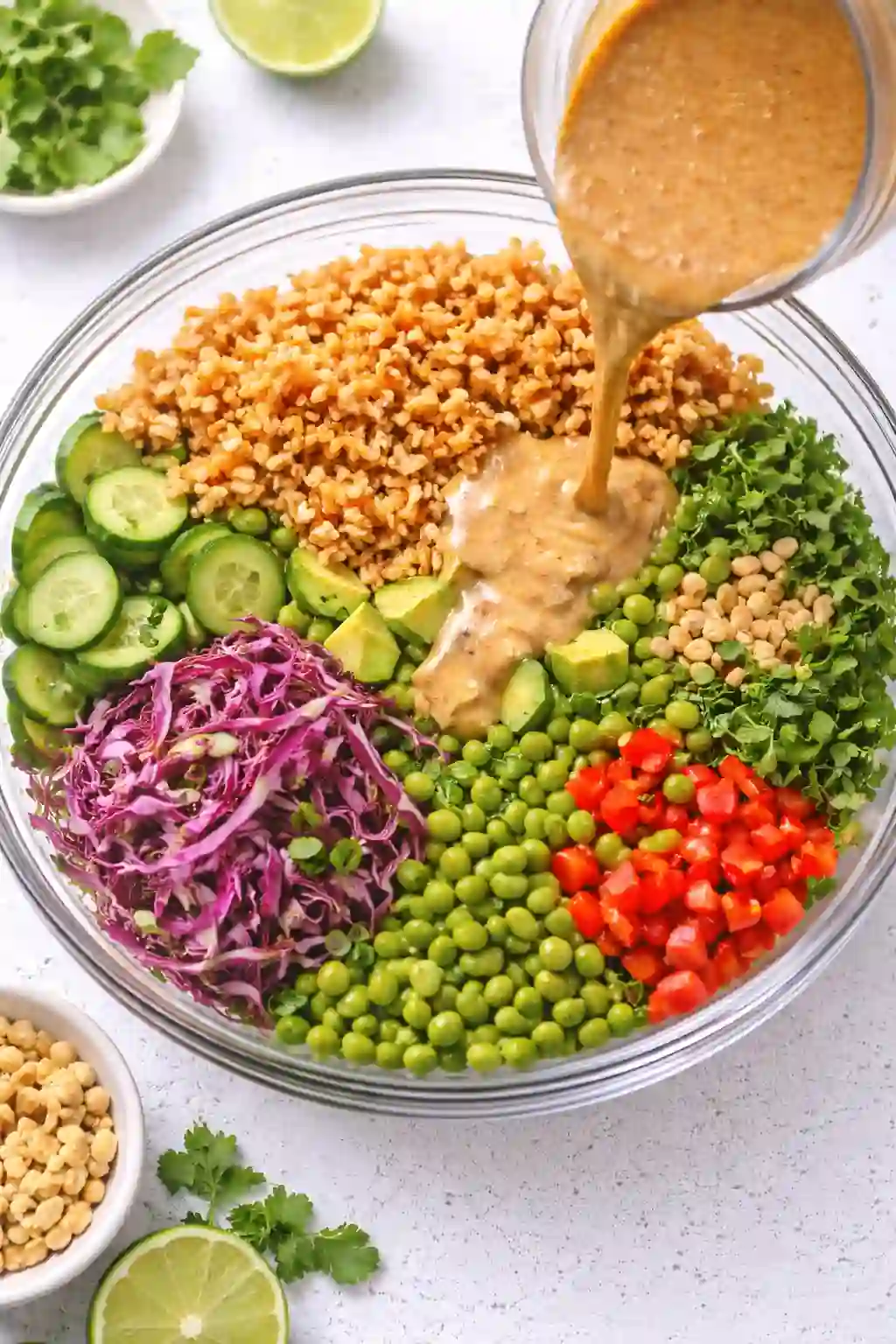 tossing crispy rice salad with peanut dressing in a large bowl