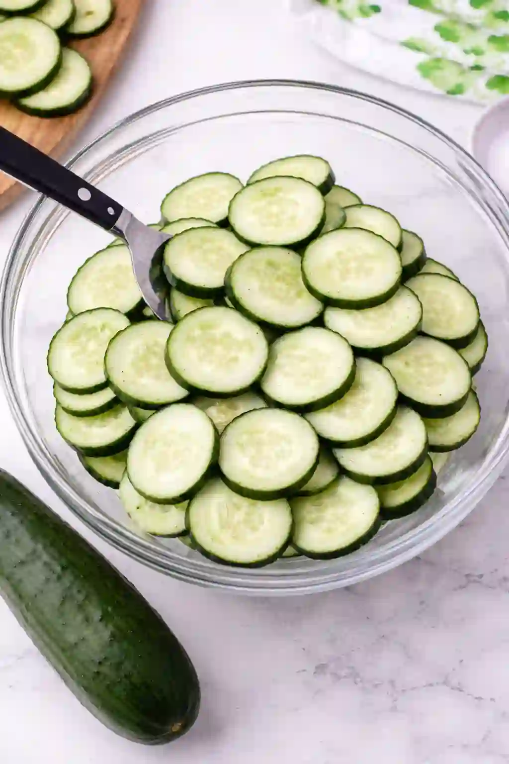 How to slice cucumbers for creamy cucumber salad in a glass bowl