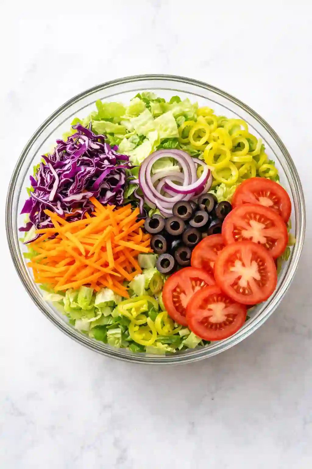 Fresh vegetables combined in a large bowl for Olive Garden salad