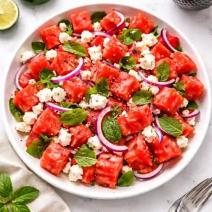 Watermelon feta salad recipe with mint and red onion served on a white plate