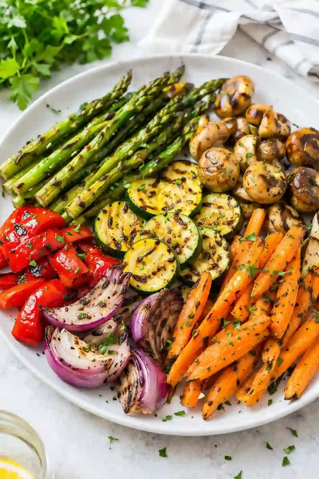 Grilled vegetables recipe served on a white plate with asparagus carrots peppers and zucchini