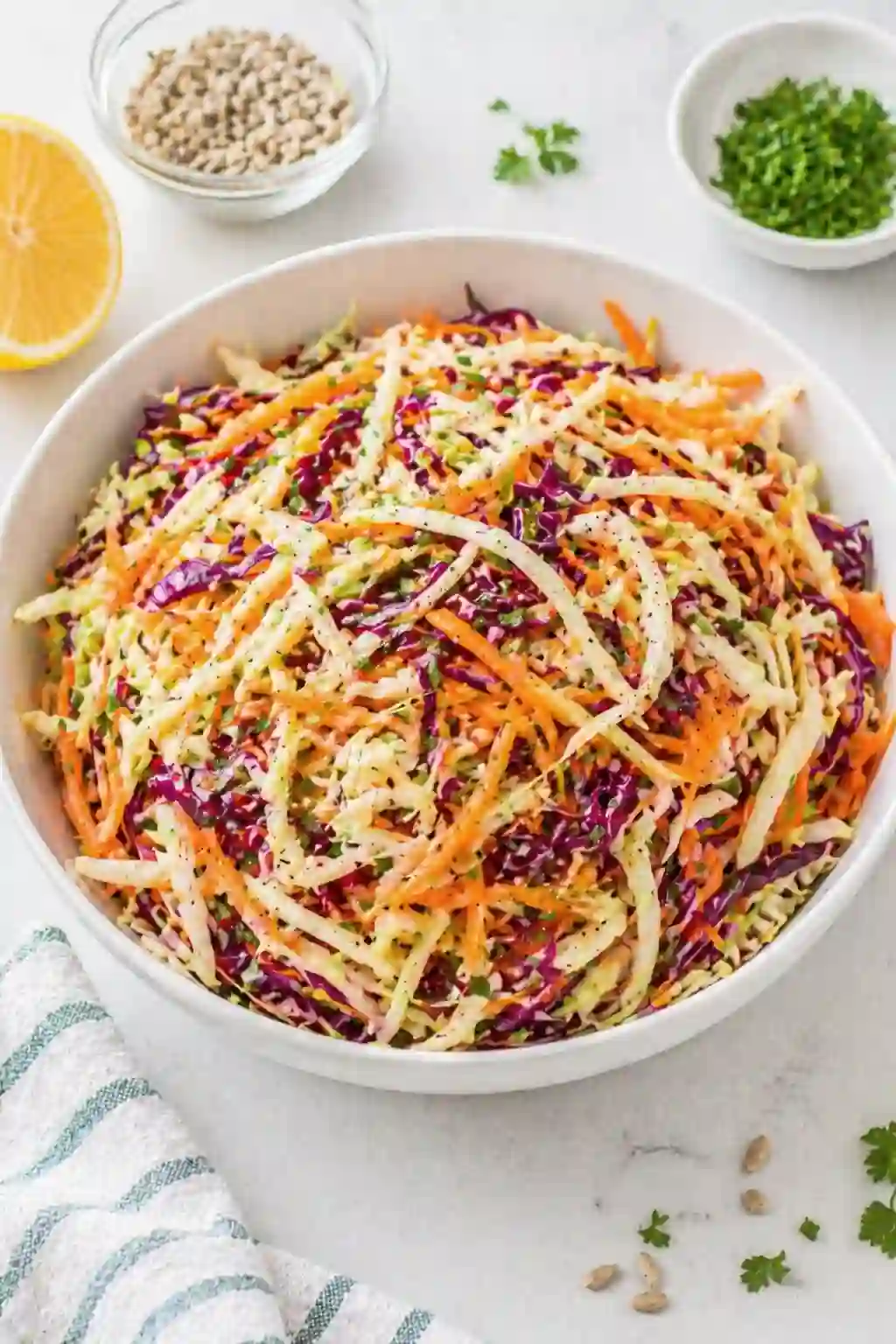Finished vinegar coleslaw in a bowl with cabbage carrots and herbs